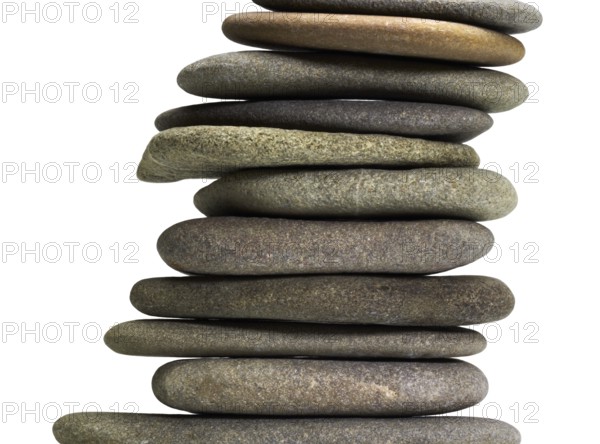 Low angle view of stacked flat pebble stones in light back