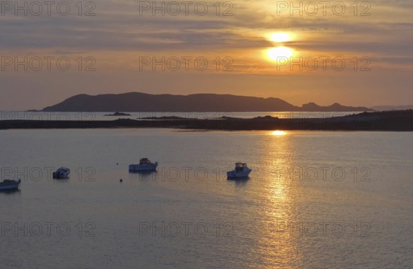 Idyllic sundown with some boats at the Pink Granite Coast in Brittany, France