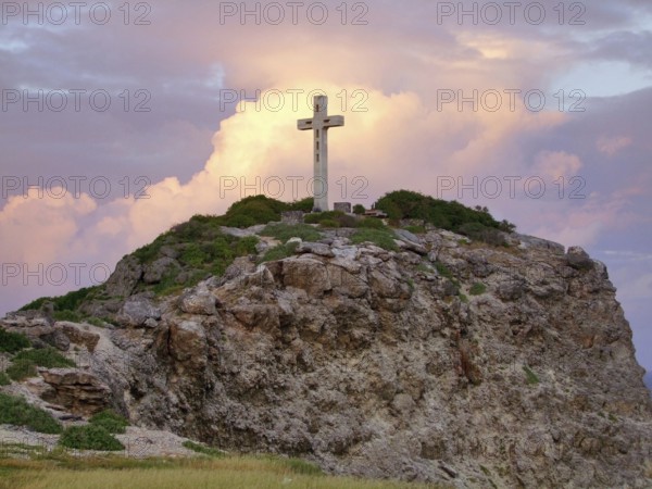 Colorful sundown scenery on a caribbean island named Guadeloupe including a summit cross on mountain top