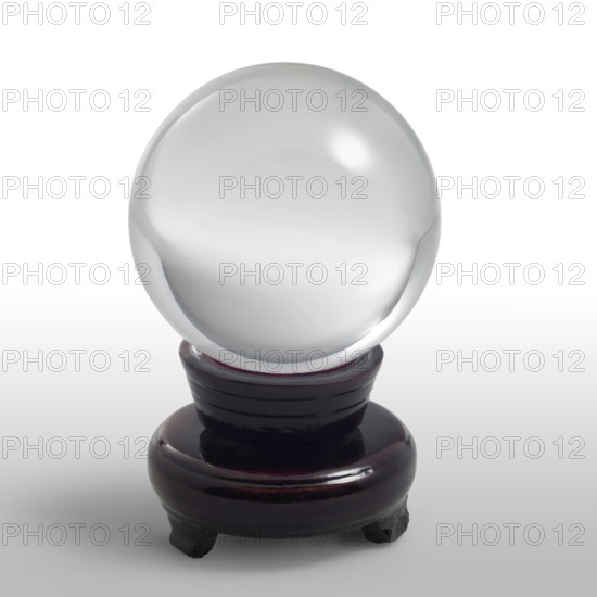 A clear crystal ball and stand in light grey gradient back