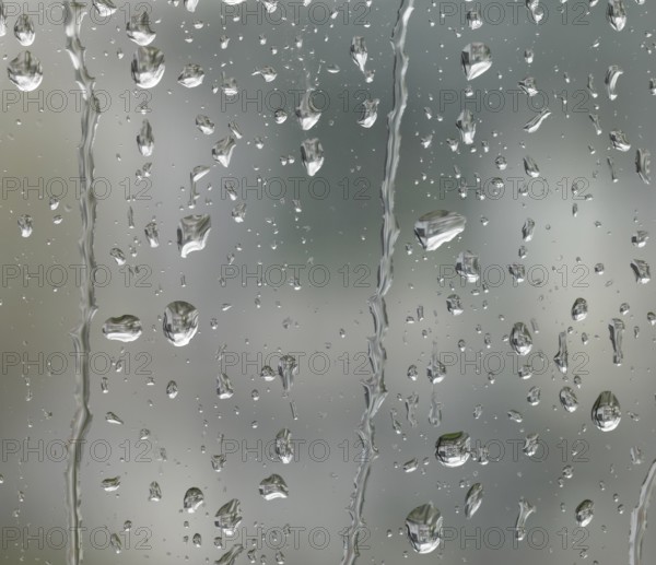 Detail of roll off raindrops on window glass