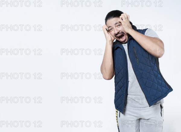 Horrified man with holding his face on isolated background