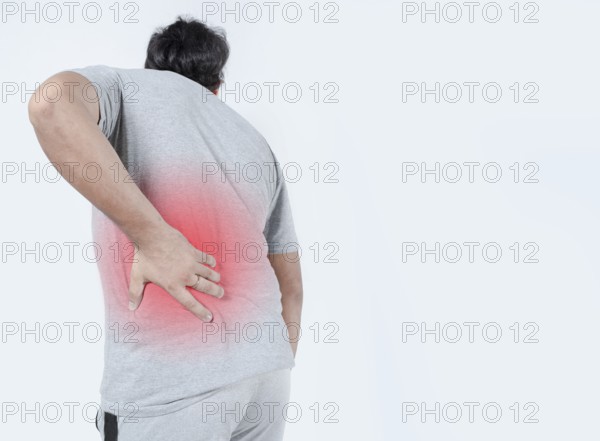 Young man with back pain highlighted in red. Male with lower back pain on isolated background