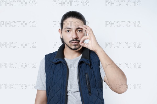 Serious man making gesture of approval. Young man making a circle with his fingers