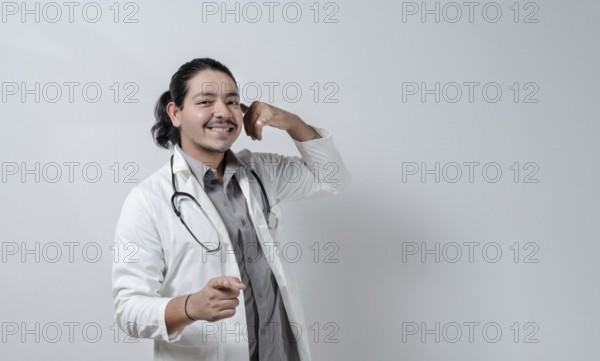 Smiling doctor pointing at you gesturing call. Doctor gesturing call
