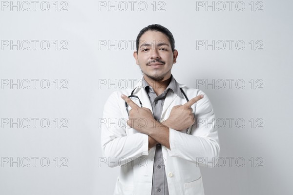 Young doctor pointing up to both sides on isolated