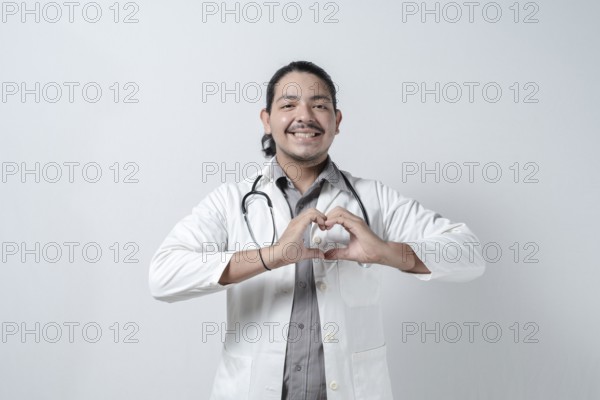 Smiling doctor making heart symbol on isolated