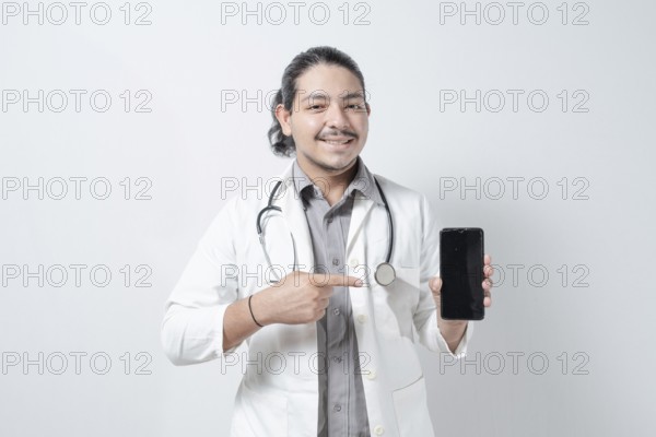 Smiling young doctor pointing at the phone