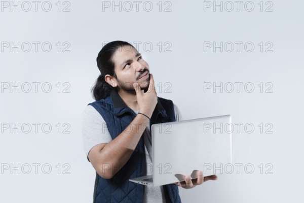 Thoughtful man with hand on chin using computer on isolated background. Man thinking holding a laptop on white background