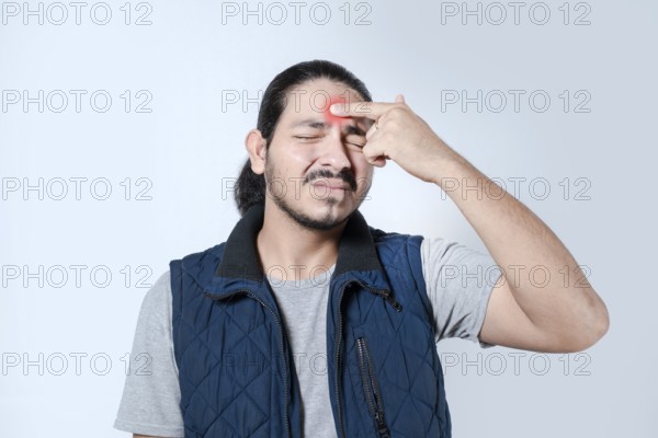 Young latino man with a headache on isolated. Male with migraine on white background
