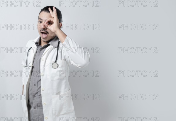 Doctor looking through his fingers. Young doctor with open mouth