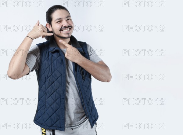 Smiling man gesturing call me on isolated background. Young man makes a calling gesture on a white background