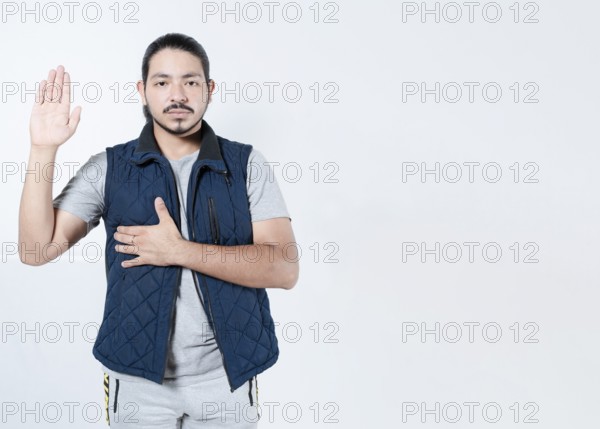 Serious man taking oath on isolated background. Young man taking an oath on white background