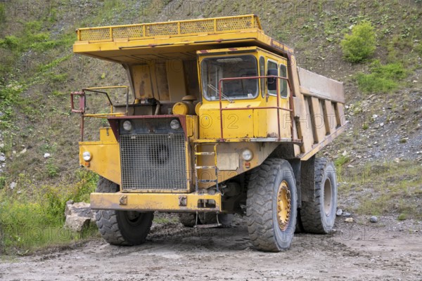 Yellow haul truck in a quarry at summer time