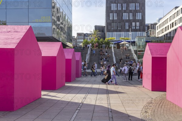 Twelve houses in bright magenta stand on Stuttgart's Schlossplatz in front of the art museum. The Pforzheim-based architecture artist Andreas Sarow developed the Exkursion art project. Stuttgart, Baden-Württemberg, Germany