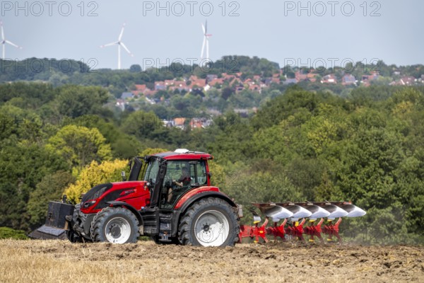 Tractor ploughs up a harvested grain field, south of Billerbeck in Münsterland, North Rhine-Westphalia, Germany