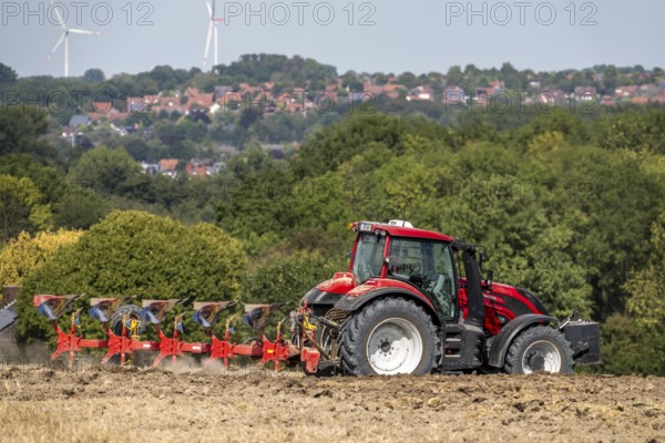 Tractor ploughs up a harvested grain field, south of Billerbeck in Münsterland, North Rhine-Westphalia, Germany