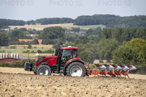 Tractor ploughs up a harvested grain field, south of Billerbeck in Münsterland, North Rhine-Westphalia, Germany