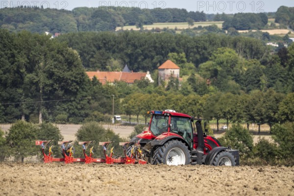 Tractor ploughs up a harvested grain field, south of Billerbeck in Münsterland, North Rhine-Westphalia, Germany