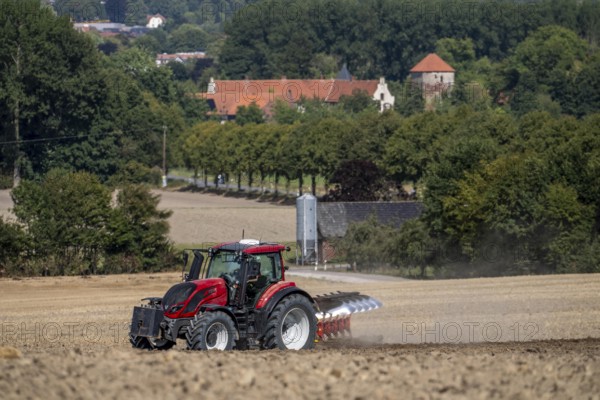 Tractor ploughs up a harvested grain field, south of Billerbeck in Münsterland, North Rhine-Westphalia, Germany