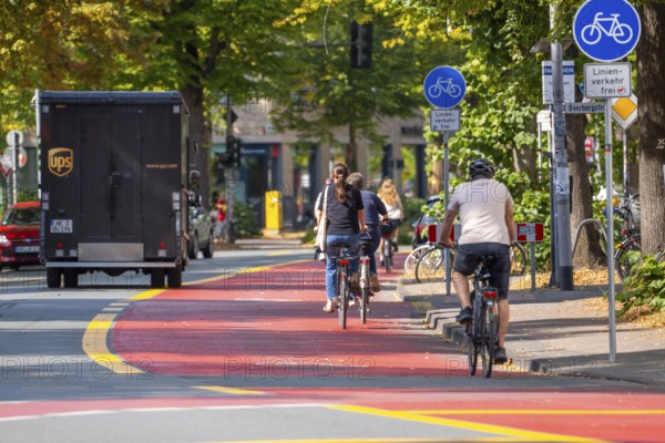 Cycle traffic in Münster, Warendorf Straße, broadly marked red asphalt as cycle path, cycle lane, colour-coded separated from the lane for cars, city centre of Münster, North Rhine-Westphalia, Germany
