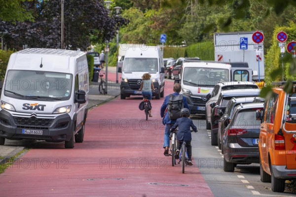 Cycling in Münster, cycle lane, Goldstraße, red asphalt and pictograms indicate to motorists that cyclists have priority, city centre of Münster, North Rhine-Westphalia, Germany