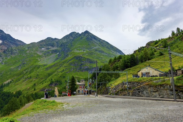 Railroad Station Alp Grüm with Mountain View in the Swiss Alps in a Cloudy Day with Sunlight in Poschiavo, Bernina, Grisons, Switzerland