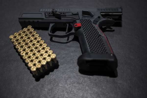 Modern Elegant Sport Handgun with Gas Pedal and Skirt and Bullet on Grey Background in Switzerland