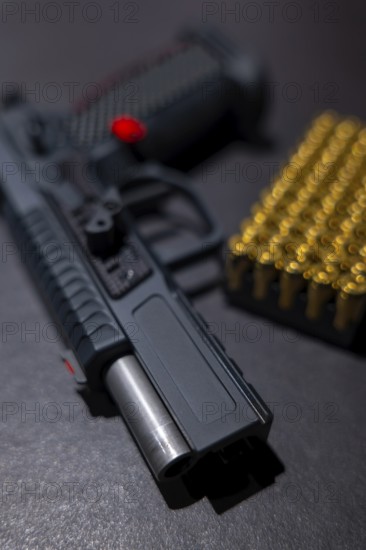 Modern Elegant Sport Handgun with Gas Pedal and Skirt and Bullet on Grey Background in Switzerland