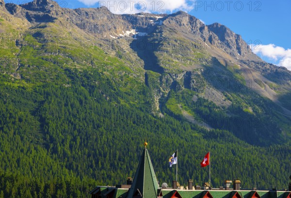 Beautiful Luxury Hotel with Swiss and Grisons and Flag Blue Sky and Mountain in the Swiss Alps in a Sunny Summer Day in St Moritz, Grisons, Switzerland