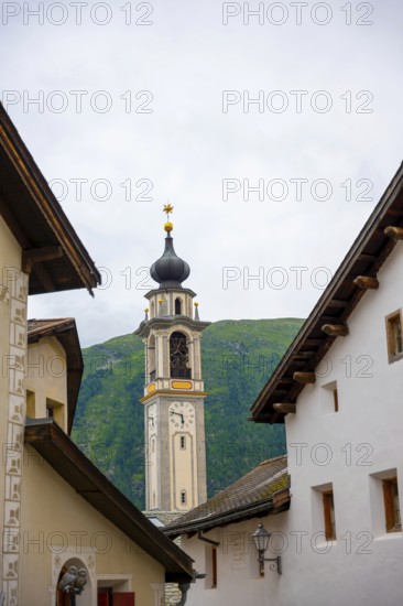 Beautiful Street in Old Town with Mountain View and Church Tower in a Summer Day in Samedan, Grisons, Switzerland
