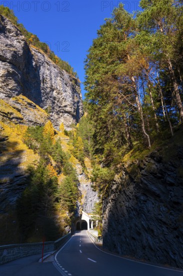 Mountain Road with Tunnel and Tree in the Swiss Alps in Mountain Valley in a Sunny Autumn Day with Blue Sky in Via Mala, Thusis, Grisons, Switzerland