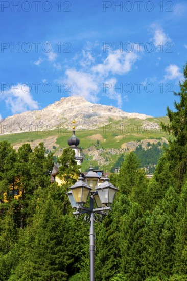 Church Tower and Street Lamp in the Forest and Mountain in the Swiss Alps in a Sunny Summer Day in Engandine, Maloja, Celerina, Schlarigna, Grisons, Switzerland