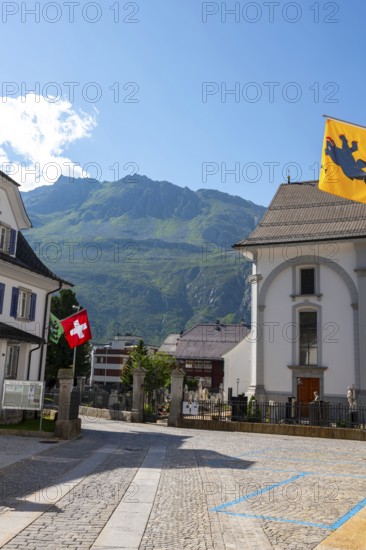 Beautiful Catholic Parish Church of St Peter and Paul in Old Town with Mountain and Blue Sky in a Sunny Summer Day in Andermatt, Uri, Switzerland