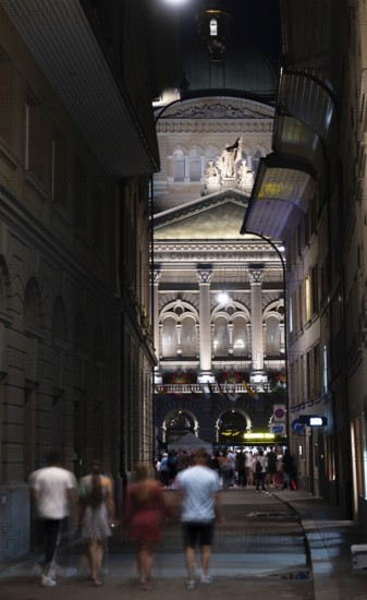 Beautiful Bundeshaus Illuminated Parliament Building or Federal Palace and a Street with People at Night in Motion in City of Bern, Bern Canton, Switzerland