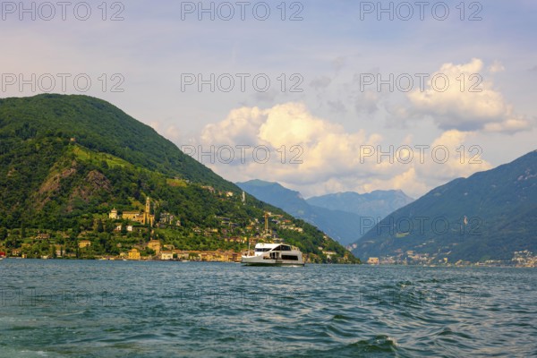 Passenger Ship on Lake Lugano and House and Church on Mountain Range in a Sunny Summer Day on the Waterfront in Morcote, Lugano, Ticino, Switzerland