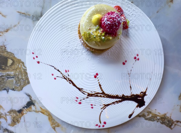 Elegant Dessert Creamy Pistachio Biscuit with Fresh Cream and Decorated with Raspberry and Chopped Pistachios in a Sunny Day with Sunlight in Italy