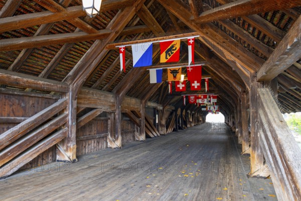 Inside the Old Historical Covered Wood Bridge Holzbrücke with Swiss Canton Flags over River Aare in a Sunny Day in Olten, Canton Solothurn, Switzerland