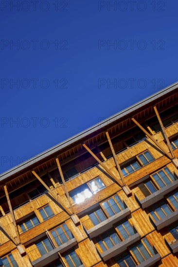 Beautiful Modern Wood Facade Building with Balcony Against Blue Clear Sky in a Sunny Summer Day in Andermatt, Uri, Switzerland