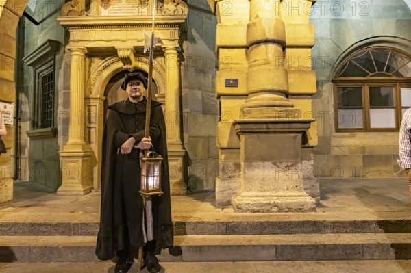 The night watchman in front of the town hall at dusk, Rothenburg ob der Tauber at dusk, Bavaria, Germany