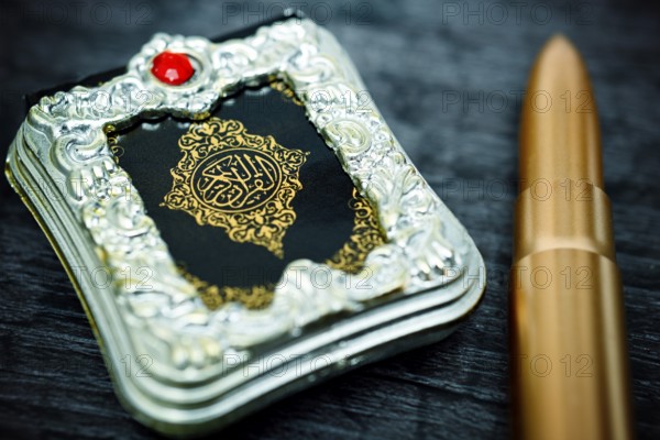 Koran and rifle cartridge, symbolic photo Islamism