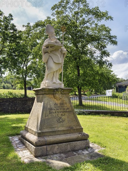 Saint Liborius, stone statue on a pedestal with inscription, parish church of St Maximilian, Willebadessen, Höxter, Teutoburg Forest nature park Park, North Rhine-Westphalia, Germany