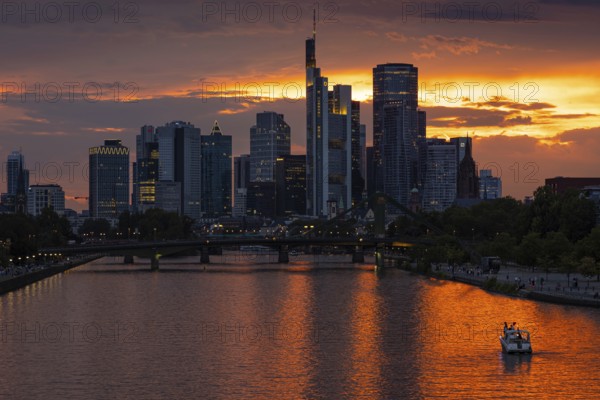The sun breaks through the clouds behind the Frankfurt banking skyline shortly in front of setting, Frankfurt am Main, Hesse, Germany