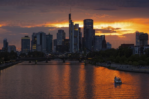 The sun breaks through the clouds behind the Frankfurt banking skyline shortly in front of setting, Frankfurt am Main, Hesse, Germany