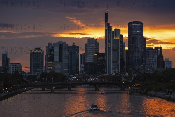 The sun breaks through the clouds behind the Frankfurt banking skyline shortly in front of setting, Frankfurt am Main, Hesse, Germany