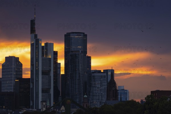 The sun breaks through the clouds behind the Frankfurt banking skyline shortly in front of setting, Frankfurt am Main, Hesse, Germany