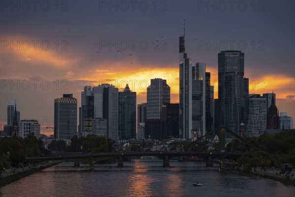 The sun breaks through the clouds behind the Frankfurt banking skyline shortly in front of setting, Frankfurt am Main, Hesse, Germany