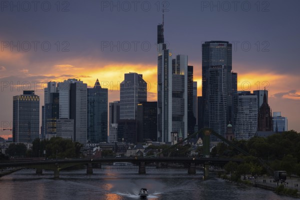 The sun breaks through the clouds behind the Frankfurt banking skyline shortly in front of setting, Frankfurt am Main, Hesse, Germany