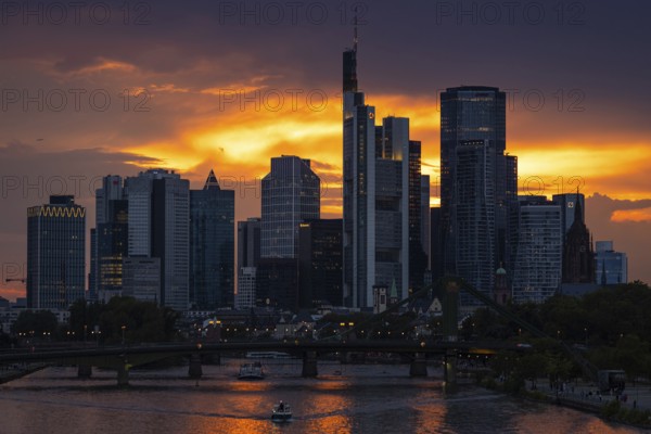 The sun breaks through the clouds behind the Frankfurt banking skyline shortly in front of setting, Frankfurt am Main, Hesse, Germany