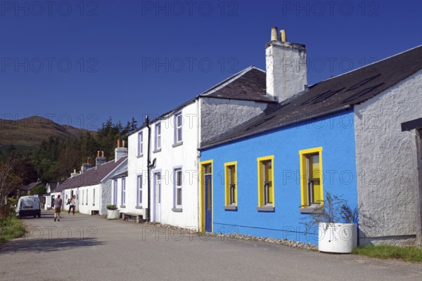 Colourful row of houses along a rural road under a bright blue sky, Knoydart, Highlands, Scotland, United Kingdom